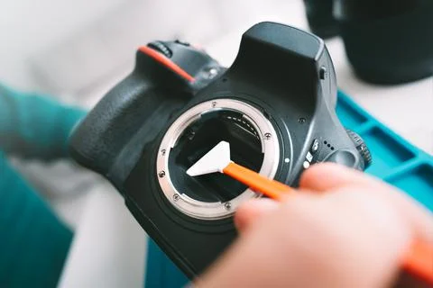 Photographer cleaning camera sensor with camera sensor cleaner or cleaning swab Stock Photos