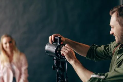 Photographer controlling the studio flash strobe lighting head. Stock Photos