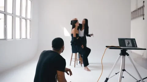 Photographer directing poses of two models in white studio Stock Footage 317783204