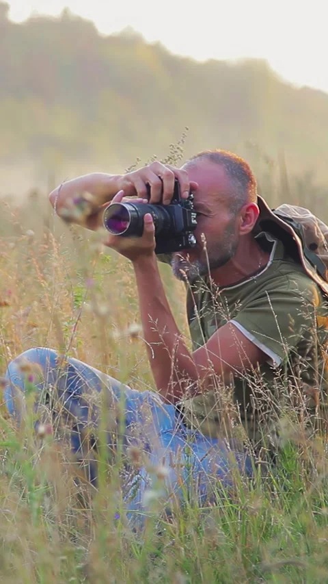Photographer doing his work in the evening sunshine. Vertical video. Stock Footage 305024127