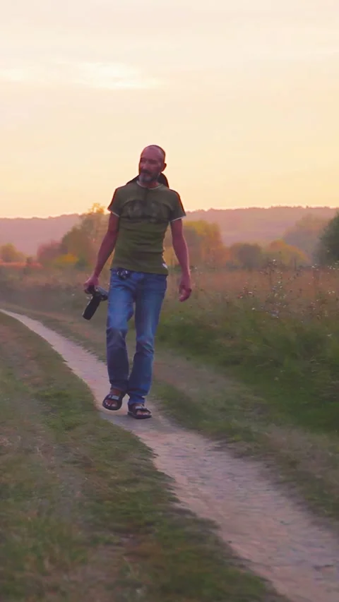 Photographer doing his work in the evening sunshine. Vertical video. Stock Footage 305024187