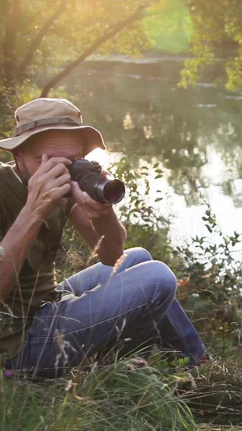 Photographer doing his work in the evening sunshine. Vertical video. Stock Footage 305024198