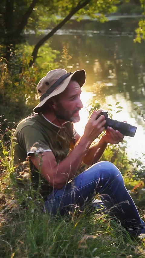 Photographer doing his work in the evening sunshine. Vertical video. Stock Footage 305024214