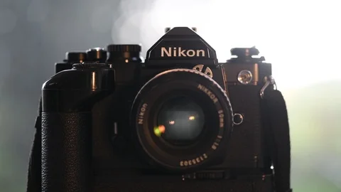 Photographer firing shutter on 35mm film camera with motor drive Stock Footage 119473388