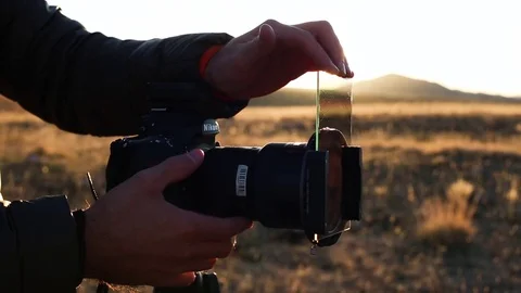 Photographer Hand mount Neutral Density Filter on the Camera Holder Video stock 84722707