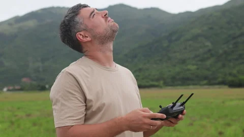 Photographer, holding drone remote control. Rice field and green hills are in Stock Footage 321991763