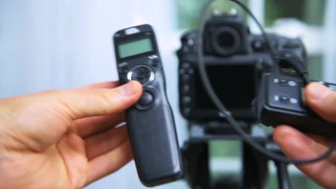 Photographer holding wireless shutter trigger release intervalometer for cameras Stock Footage 136869364
