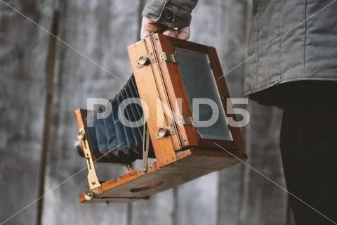 Photographer holds vintage large format studio camera. Concept - photography Stock Photos