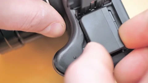 Photographer inserts battery into professional camera. Professional artist has Video stock 233291968