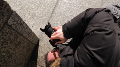 Photographer laying on ground taking creative photo 1 Stock-Footage 87709237