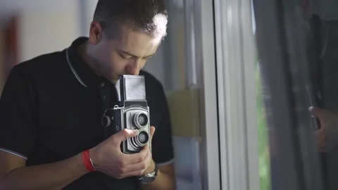 Photographer man capturing images using a vintage retro twin-lens reflex came Stock Footage 311133402