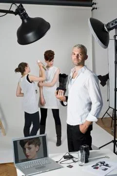 A photographer, model and make-up artist on set of a fashion shoot Stock Photos
