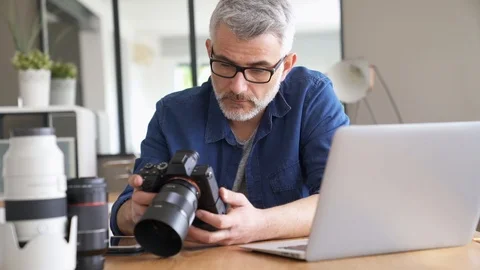 Photographer in office checking shots Stock Footage 103287489