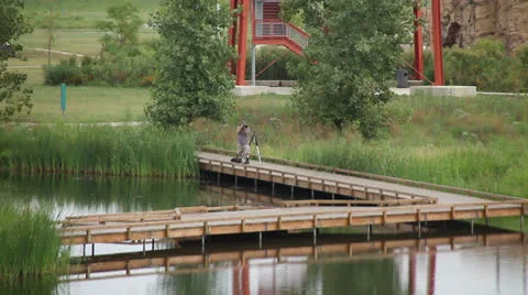  PHOTOGRAPHER AT POND Stock Footage 23018950