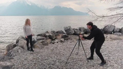 Photographer posing a blonde model with Lake Geneva at a beach in Montreux Video stock 333147484