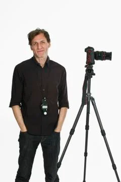 A photographer posing next to his camera on a tripod Foto stock