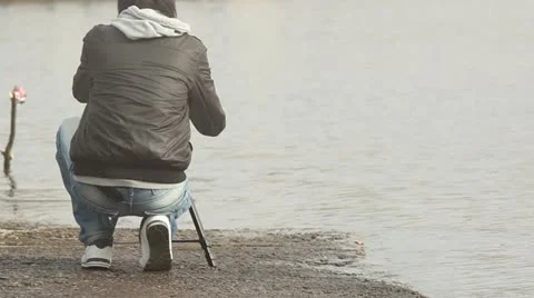 Photographer at the riverside with camera on tripod Stock Footage 10864711