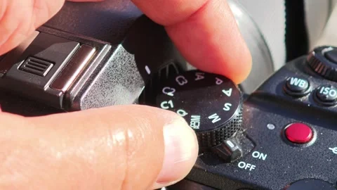 Photographer rotating camera mode dial Видео 312122397