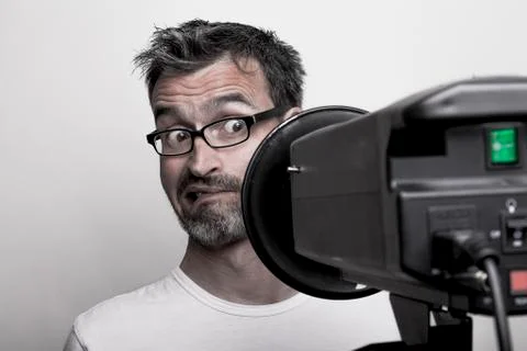 Photographer sceptically looks into a studio strobe Stock Photos
