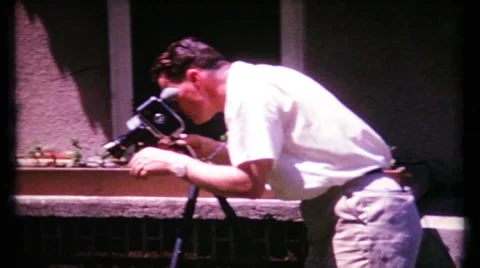 Photographer sets camera on tripod for next shot 1950s vintage home movie 466 Stock Footage 30464597