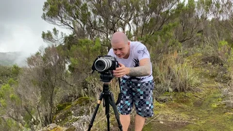Photographer sets up his big camera on a tripod to capture the nature of Africa 動画素材 168861379