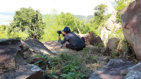 The photographer is setting the camera to shoot. Stockbeeldmateriaal 95683107