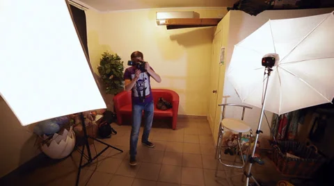 Photographer in the studio showing the model how to pose and photographed her Stock Footage 29675855