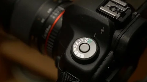 Photographer switching a DSLR camera from automatic to manual settings Stock Footage 85035993
