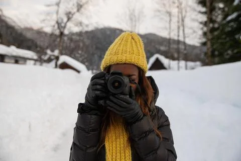 A photographer takes a picture while standing in a mountain scenery in the .. Stock Photos