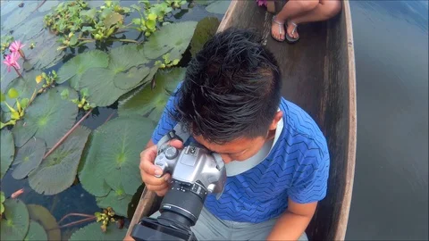 Photographer Taking Picture While riding a canoe in the Lake with Lotus Video stock 92094680
