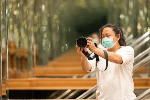 Photographer using camera to taking Self Portrait in the mirror.Photographe.. Stock Photos