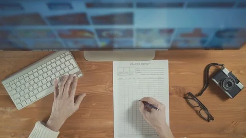 Photographer using display and keyboard to select photos from computer display Stock Footage 72503991