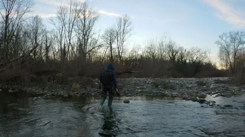 Photographer walking along a stream Stock Footage 301867477