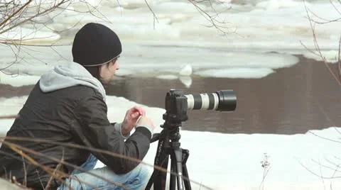Photographer at winter river side, ice and snow around Video stock 10834196