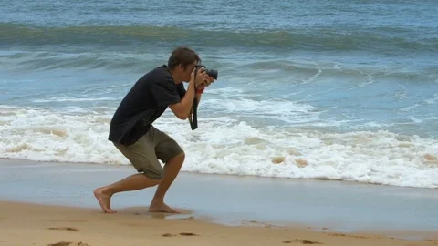 Photographer at work on the background of the raging ocean waves Stock Footage 73563834