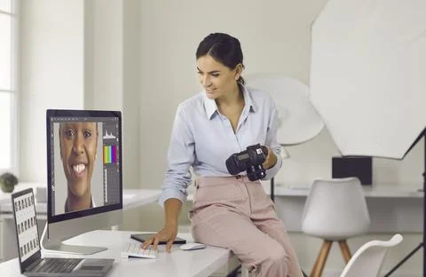 Photographer working in her creative studio and editing pictures on her computer 스톡 사진