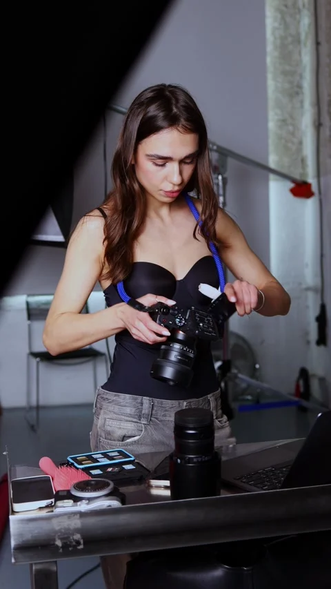 Photographer working on laptop in studio setting with camera gear Stock Footage 305027714