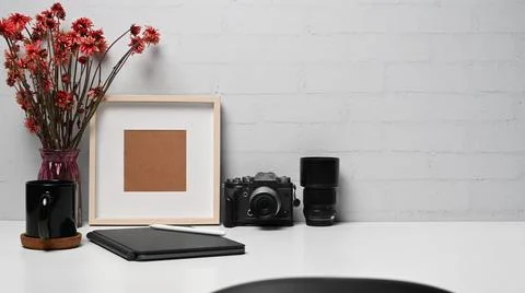 Photographer workplace with camera, digital tablet, coffee cup and picture frame Stock Photos