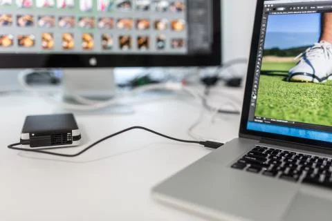 Photographers computer with photo edit apps/programs running - images being w Fotos Stock