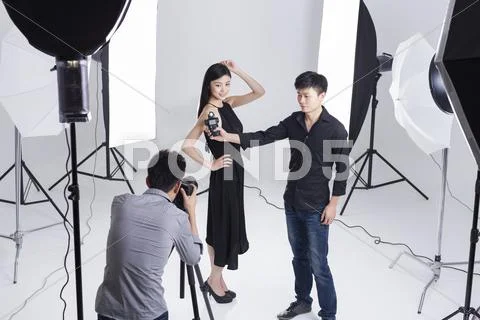Photographers taking pictures of female model in studio Stock Photos
