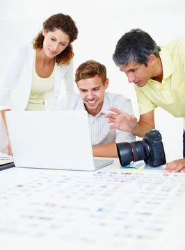 Photographers using laptop. Photographers using laptop and discussing with each Stock Photos