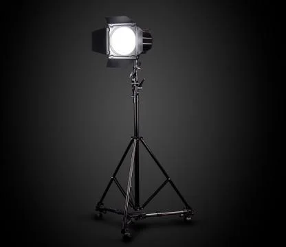 Photography studio flash on a lighting stand isolated on black background. Stock Photos