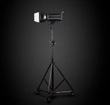 Photography studio flash on a lighting stand isolated on black background. Stock Photos