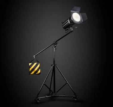 Photography studio flash on a lighting stand isolated on black background. Stock Photos