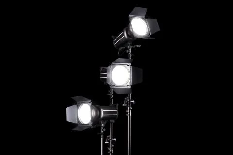 Photography studio flash on a lighting stand isolated on black background. Stock Photos
