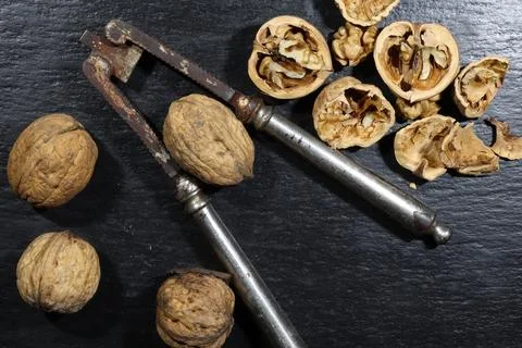 Photography of a very old nutcracker and walnuts on a slate for food backgrou Stock Photos