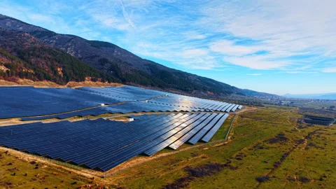 Photovoltaic solar array on hillside with grazing cattle. Solar panels installed Video stock 329192229