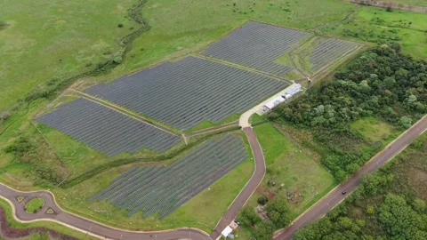 Photovoltaic solar array in rural green field. High aerial orbit on cloudy day 库存影片 343989849