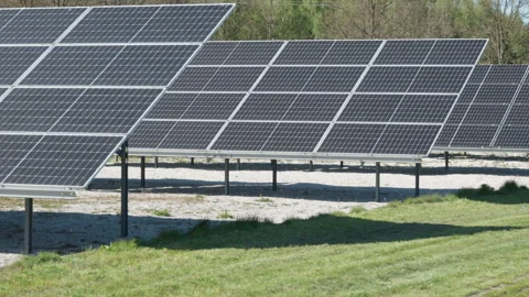 Photovoltaic solar panel array generating clean electricity in a field Stock Footage 333982668