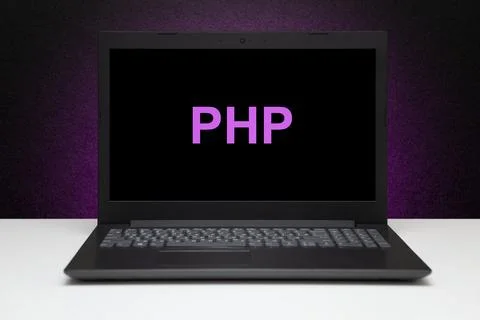 PHP text on laptop screen on textured black background with purple light. Stock Photos